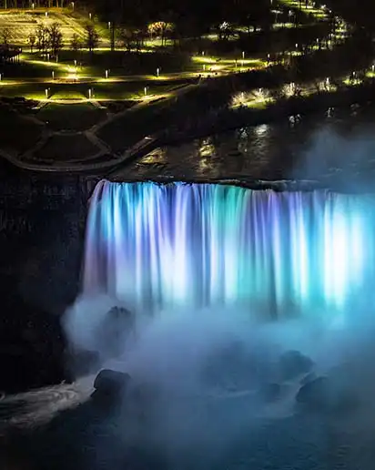 Night view of Niagara Falls with illuminated water and skyline backdrop