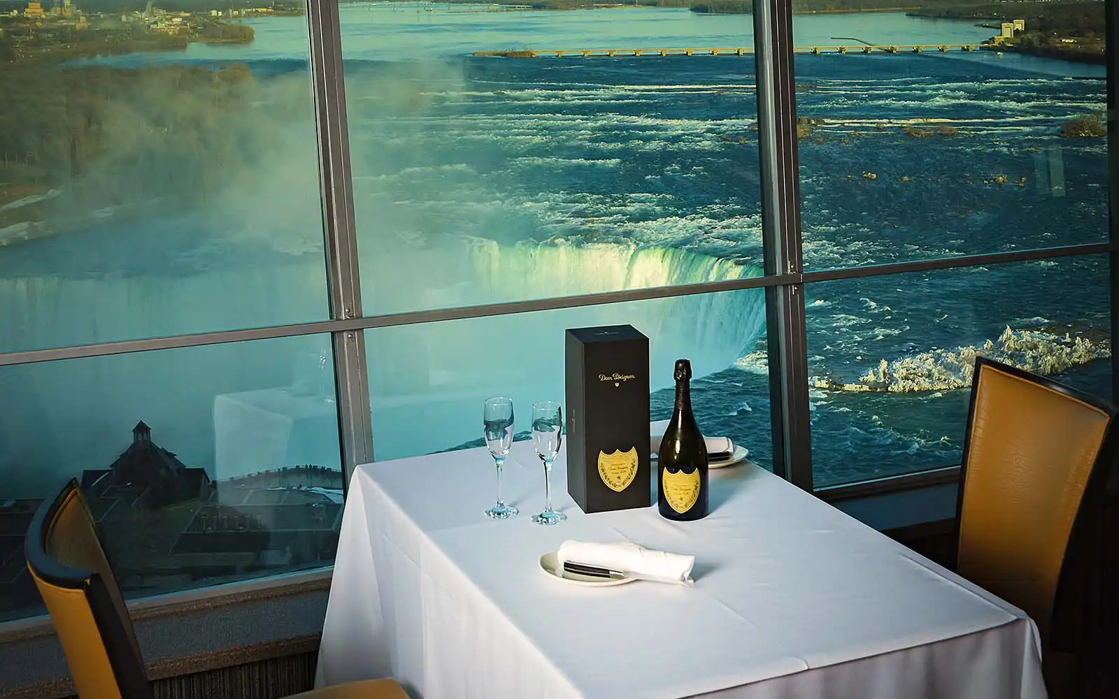 Fallsview dining room with table settings and full-height windows