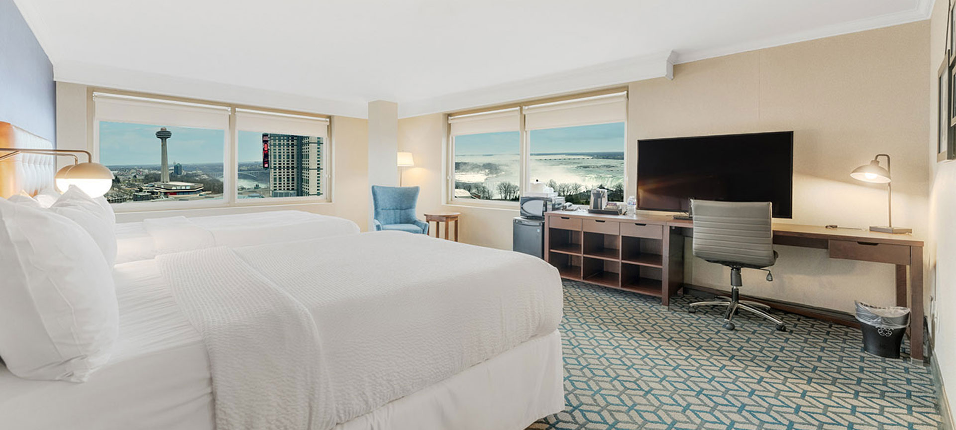 King fallsview room with floor-to-ceiling windows and lounge chair